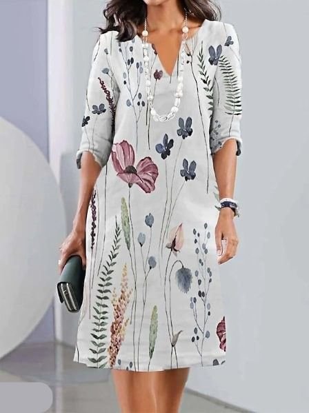 Elegant plus size tunikakjole med blomstermønster og V-udskæring, perfekt som sommerkjole i lysegrå.