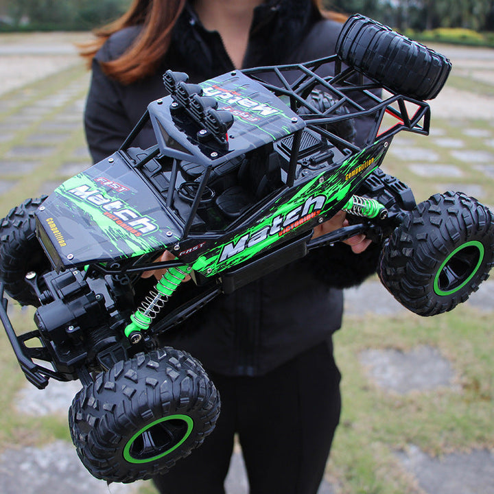 Rød fjernstyret 4WD monster truck med store hjul kører gennem mudret terræn.