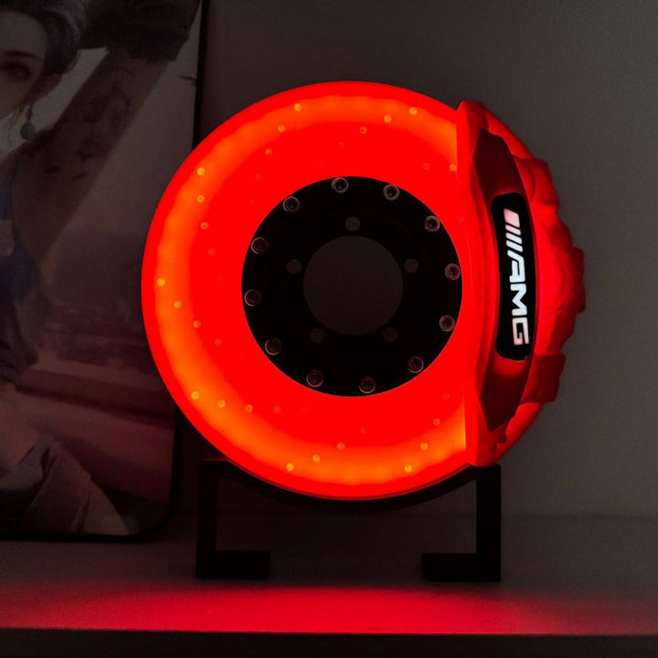 Gul skrivebordslampe med innovativt bremse-design, ideel gave til bilentusiasten med trådløs oplader.