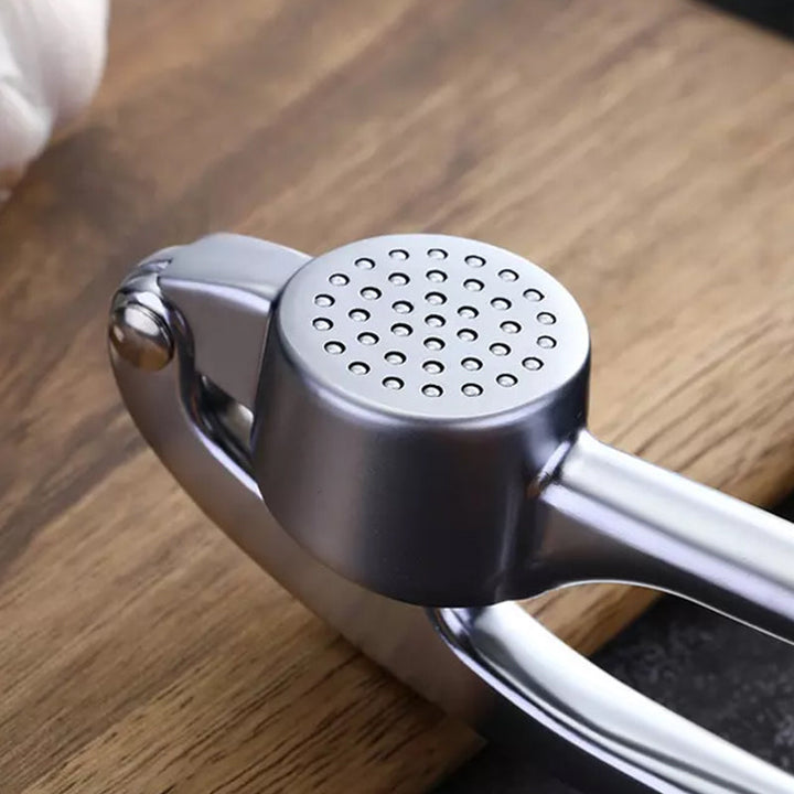 Robust hvidløgspresser i rustfrit stål med ergonomisk håndtag, stort kammer, ideel til køkkenet, nem at rengøre.