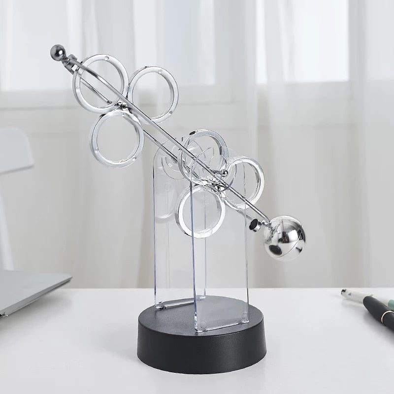 Roterende evighedspendel, dekorativt ornament med elegant dobbelt-trippelring design, lydløst og hypnotisk.