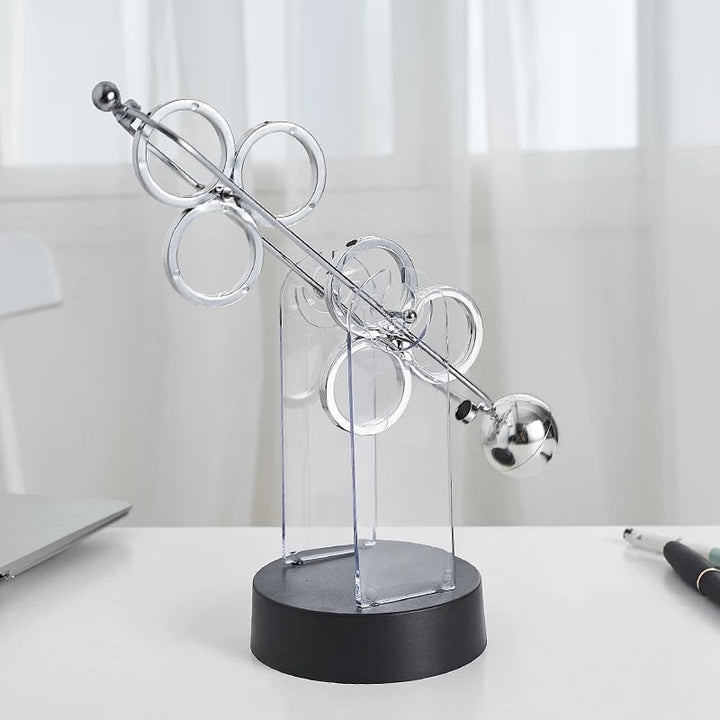 Roterende evighedspendel, dekorativt ornament med elegant dobbelt-trippelring design, lydløst og hypnotisk.