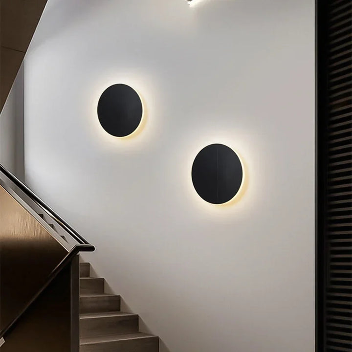 Rund, moderne LED-væglampe med elegant, minimalistisk design, ideel til stilfuld indendørsbelysning.