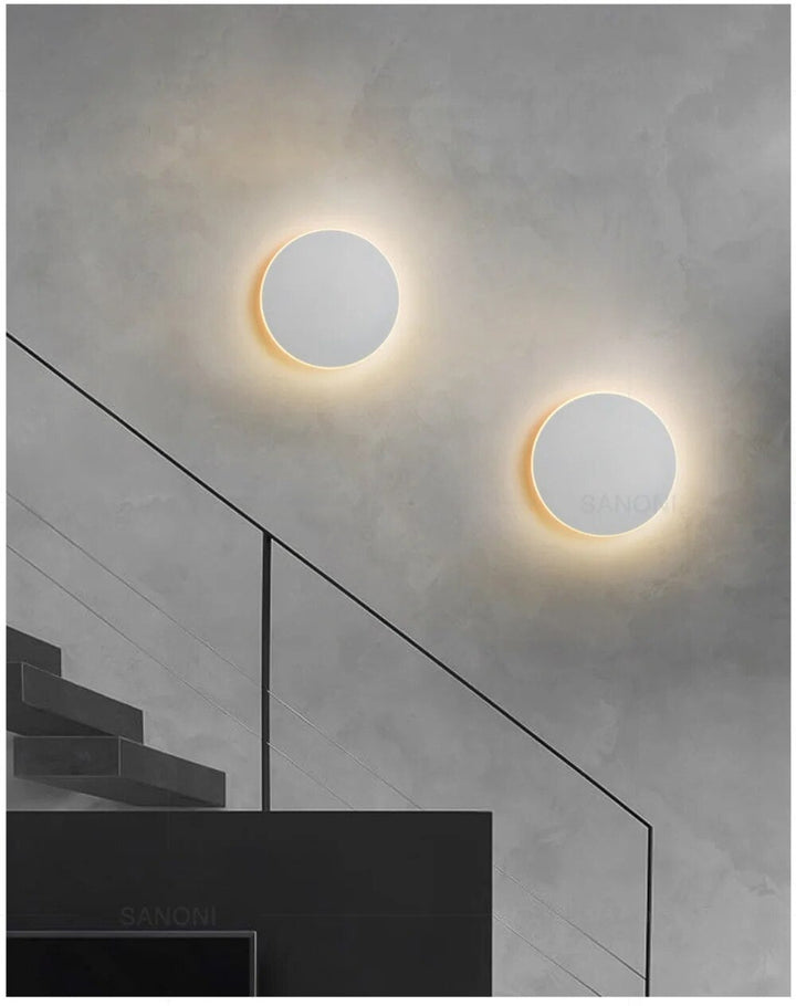 Rund, moderne LED-væglampe med elegant, minimalistisk design, ideel til stilfuld indendørsbelysning.