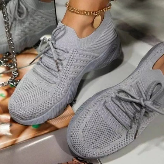 Letvægts kvindesneakers i hvid/grå, perfekte til daglig gang og fritidsbrug med god svangstøtte.