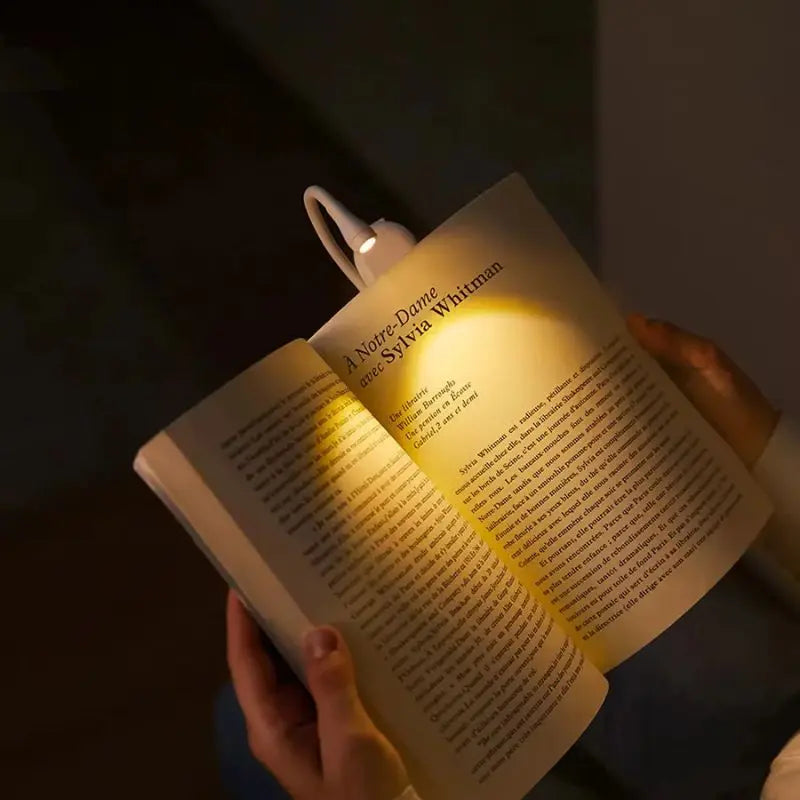 Sort, fleksibel læselampe med 360° rotation og genopladelig bogklemme samt dæmpbare LED'er, ideel til læsning.