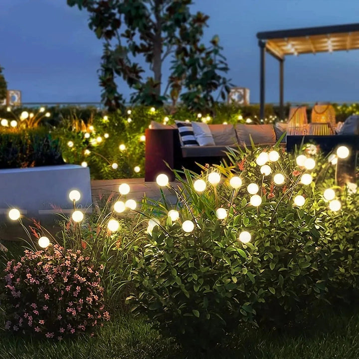 Solardrevne ildflue-havelamper lyser med varmt lys, energieffektive og vejrbestandige, forvandler haven til en lys-oase.
