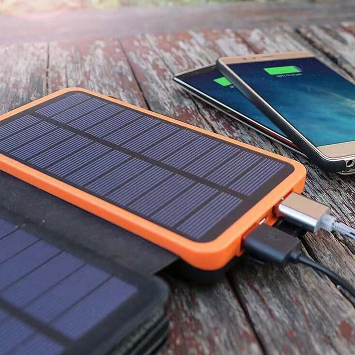 Solcelledrevet powerbank 25000mAh med fire solpaneler, LED'er, robust design til udendørs eventyr og hurtig opladning.