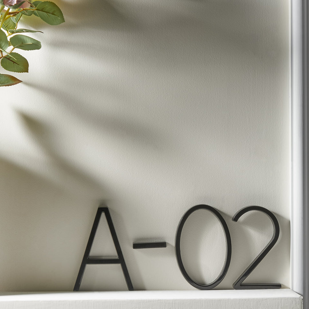 Sorte husnumre i minimalistisk design, der komplimenterer enhver moderne boligfacade.