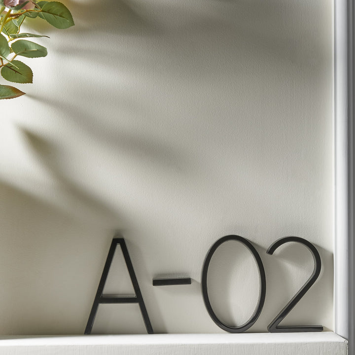 Sorte husnumre i minimalistisk design, der komplimenterer enhver moderne boligfacade.