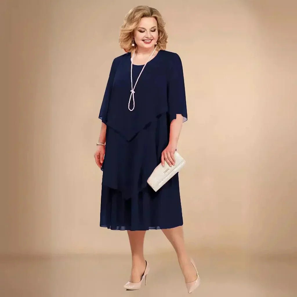 Blå elegant plus size kjole til bryllupsgæst. Asymmetrisk chiffon design, knælang aftenkjole.