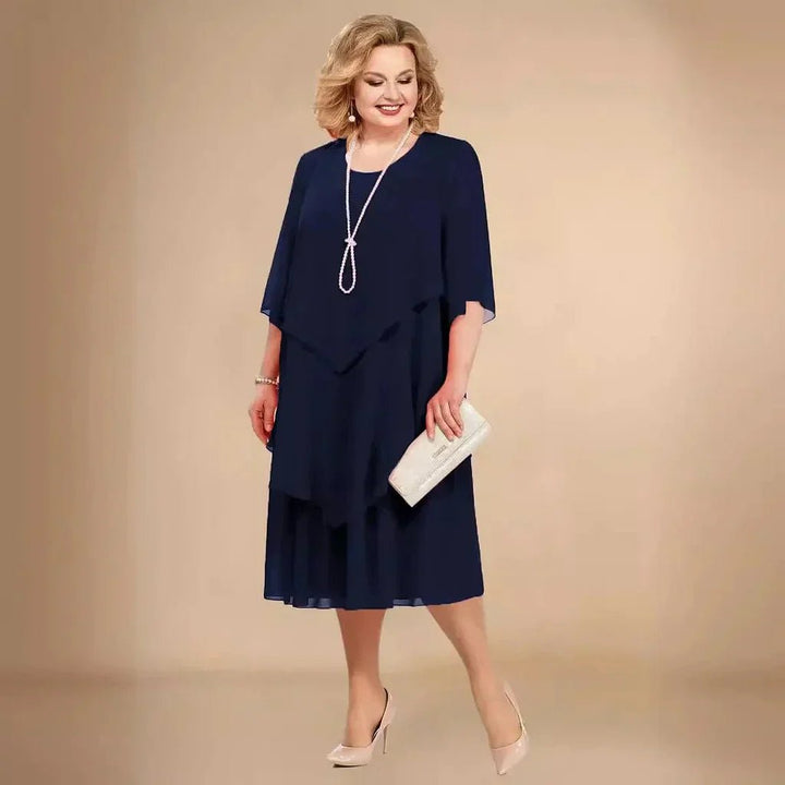 Blå elegant plus size kjole til bryllupsgæst. Asymmetrisk chiffon design, knælang aftenkjole.