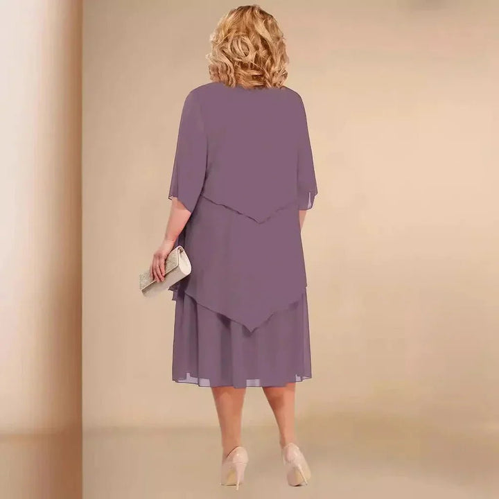 Elegant plus size damekjole i chiffon med smukke asymmetriske lag. Ideel knælang festkjole til store størrelser.