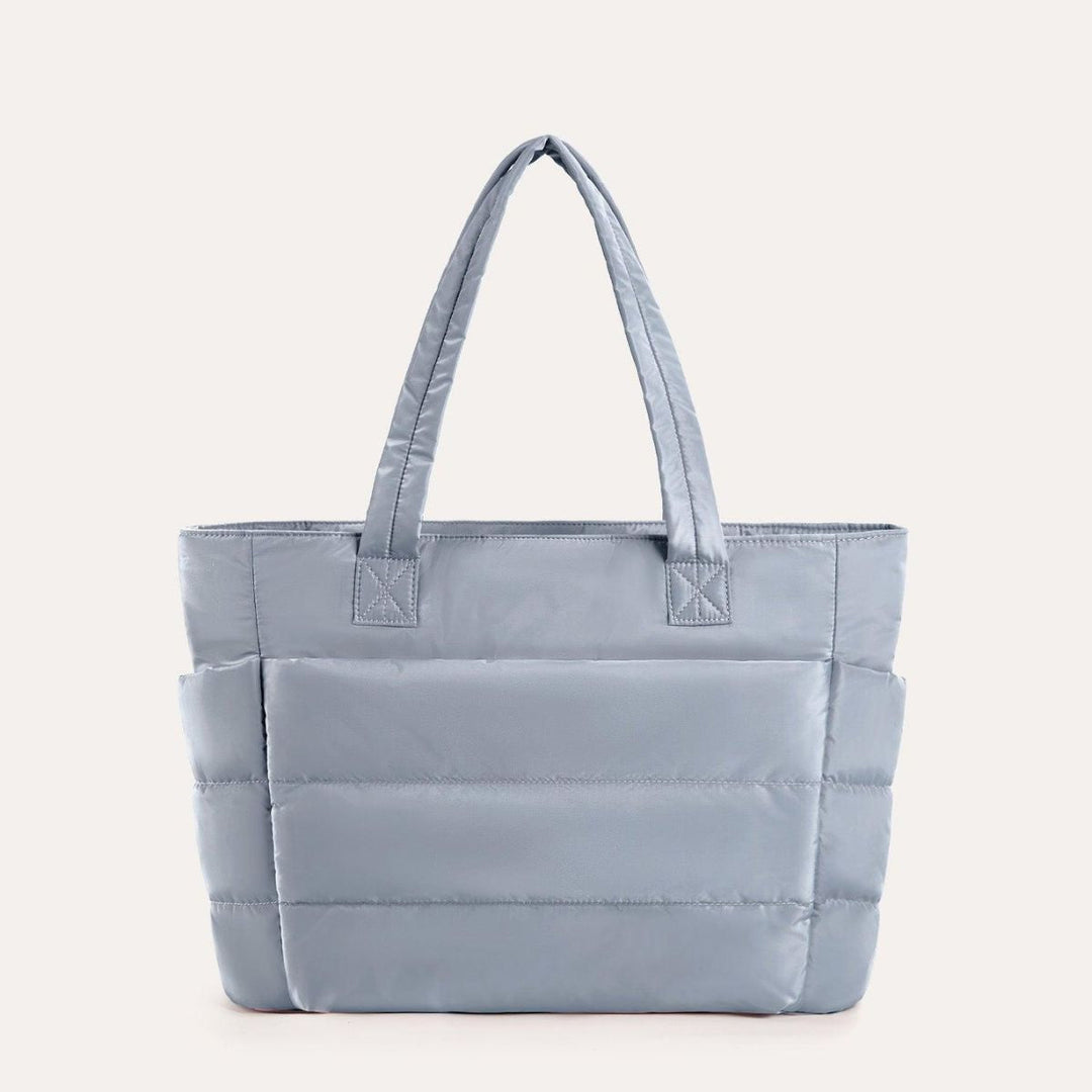 Oversigt over den store åbning på dame puffy tote tasken, der viser dens rummelighed.