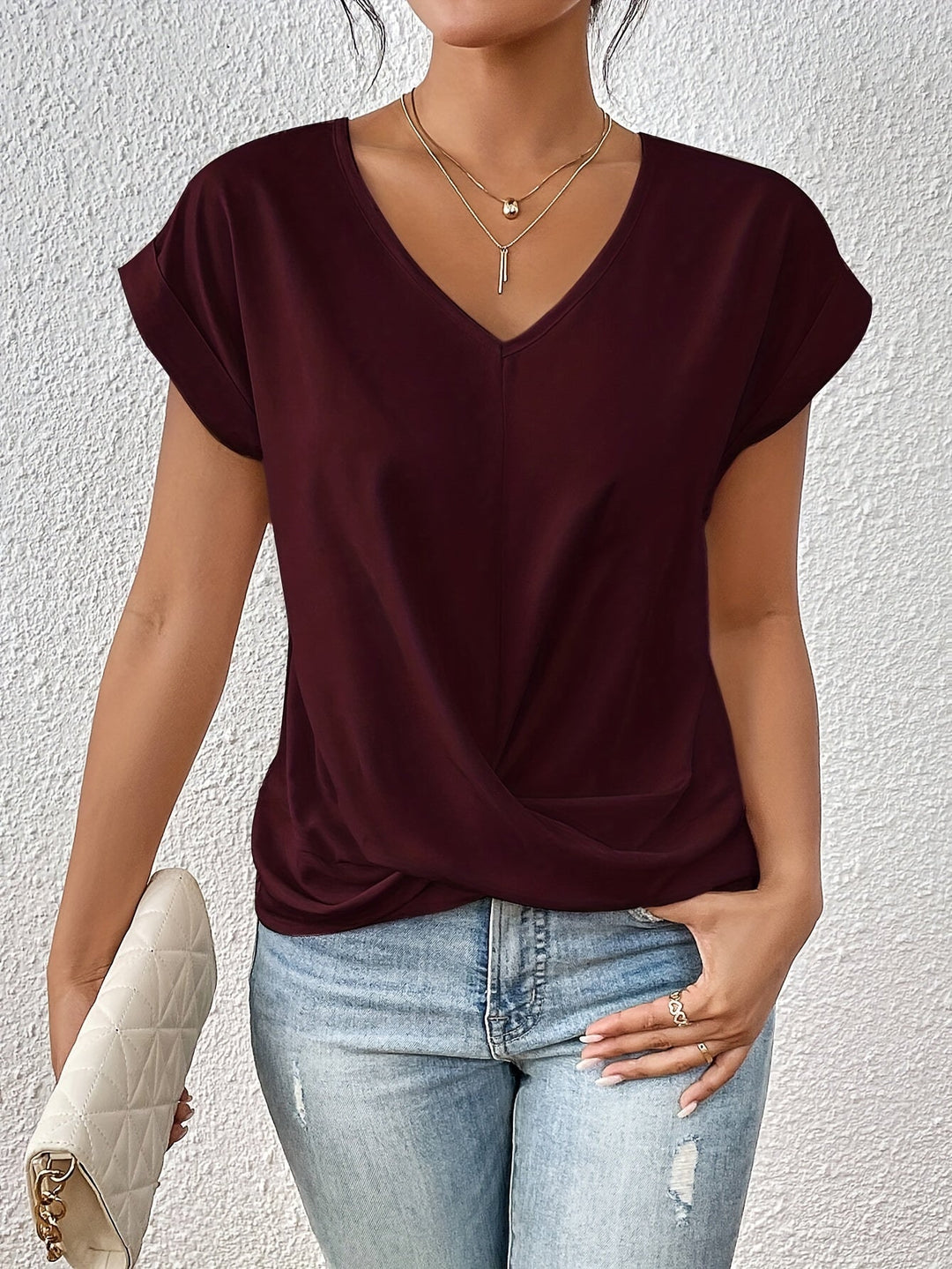 Elegant V-hals bluse til damer med en unik knudedetalje, ideel til moderne kvindetøj.