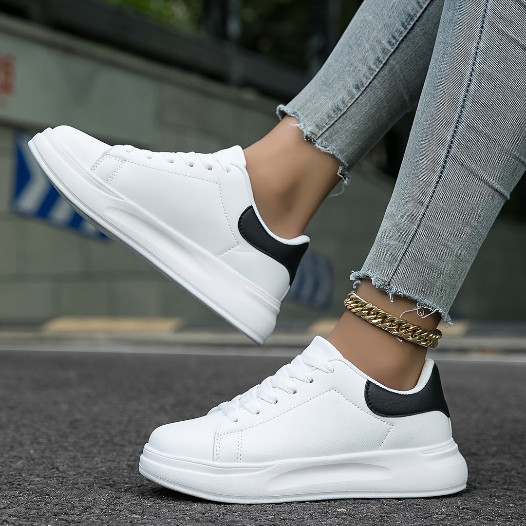 Hvide dame sneakers med sorte detaljer for et rent, moderne og stilfuldt hverdagslook.