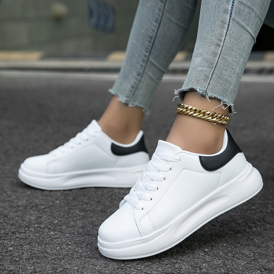 Sidebillede af moderne hvide dame sneakers med stilfulde sorte accenter, ideelle til casual brug.