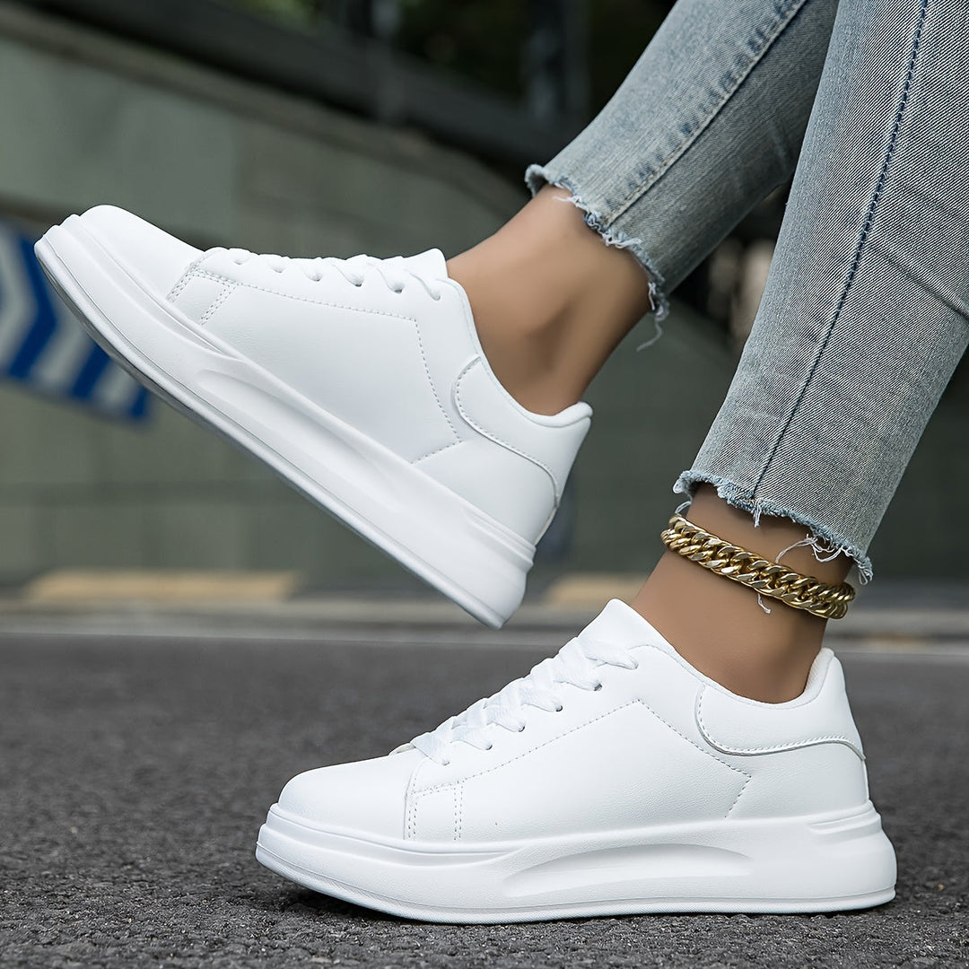 Kvinde iført moderne hvide dame sneakers, fremhæver skoenes stil og komfort i hverdagen.