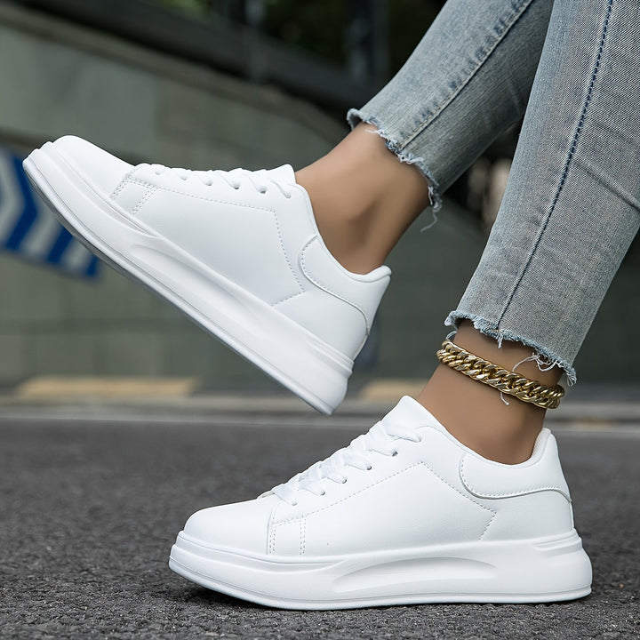 Kvinde iført moderne hvide dame sneakers, fremhæver skoenes stil og komfort i hverdagen.