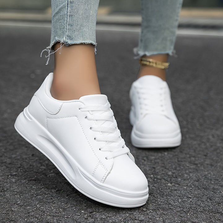 Bagside af moderne dame sneakers i hvid/sort design, perfekt til streetwear og stilfulde outfits.