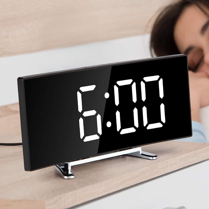 Nærbillede af det digitale display på et buet LED vækkeur med tydelige tal.
