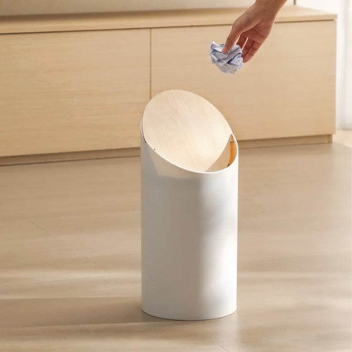 En flot affaldsspand i træ med skrå design, fremstillet i ahorn for et moderne hjem.