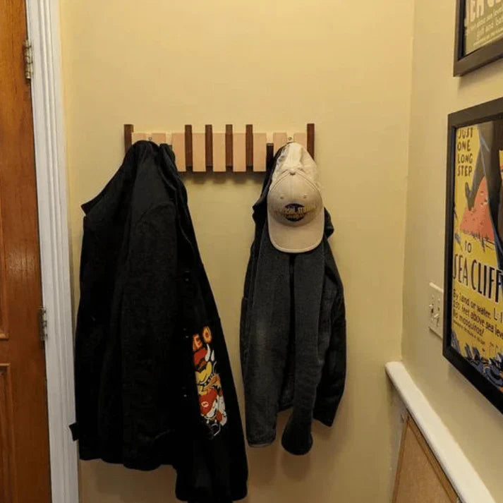 Stilfuld træ piano garderobe med klaverformede knager, ideel til gangen eller kontoret, fremstillet af robust træ.