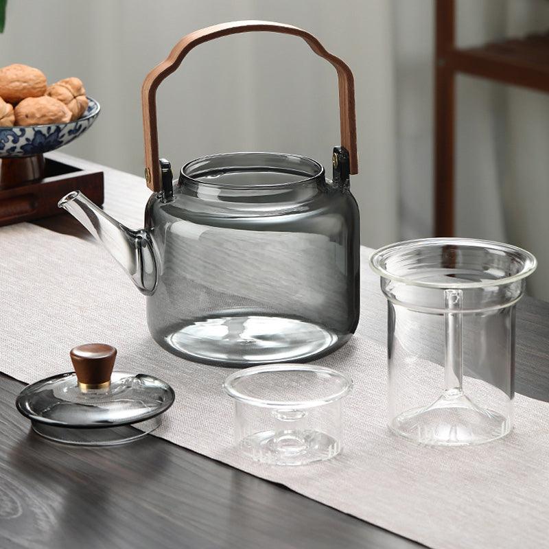 Stilfuld tekande i glas og træ med elegant design og ergonomisk greb, ideel til teceremonier.