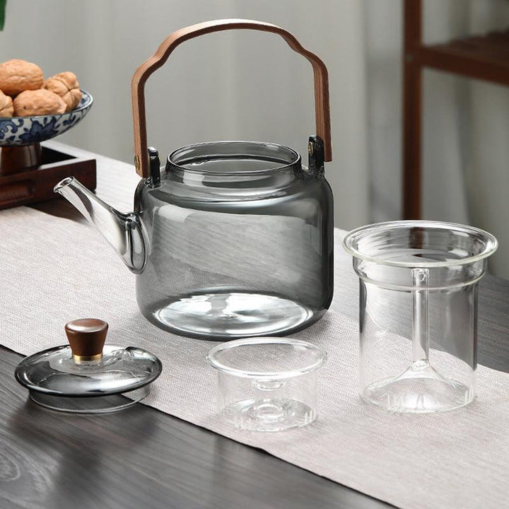 Stilfuld tekande i glas og træ med elegant design og ergonomisk greb, ideel til teceremonier.
