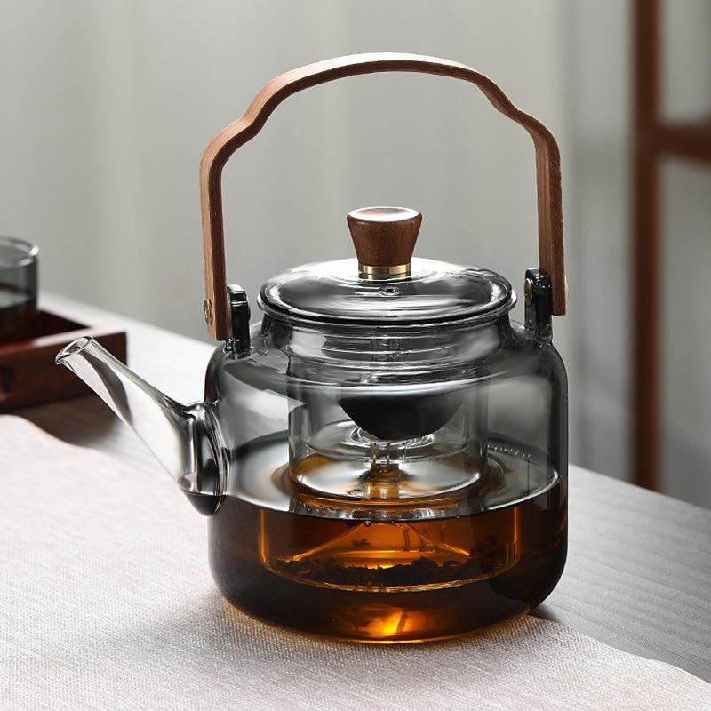 Stilfuld tekande i glas og træ med elegant design og ergonomisk greb, ideel til teceremonier.
