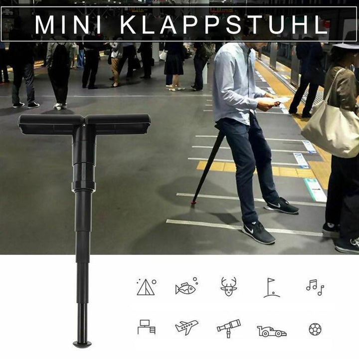 Transportabel sort mini klapstol til udendørs brug, let og kompakt, en person sætter den glad op udendørs.