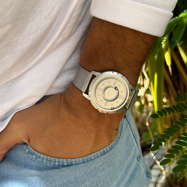 Stilrent unisex magnetisk armbåndsur med sort mesh armbånd og unikt kugledisplay. Innovativt.