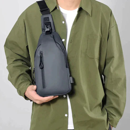Crossbody taske i moderne stil, vandtæt med USB-port, vist båret af model.
