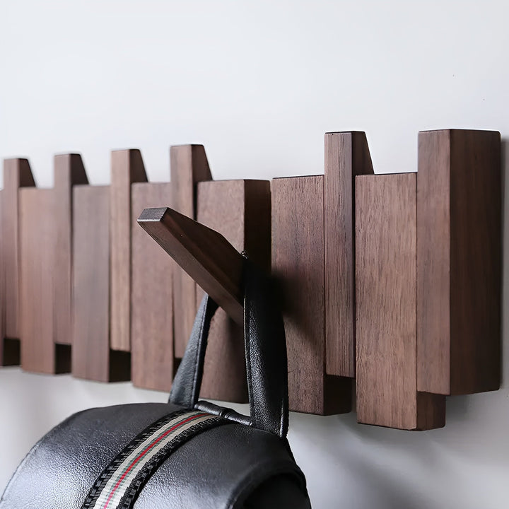 Vægmonteret foldbar træ knagerække i lukket stand, en minimalistisk løsning til entréen.