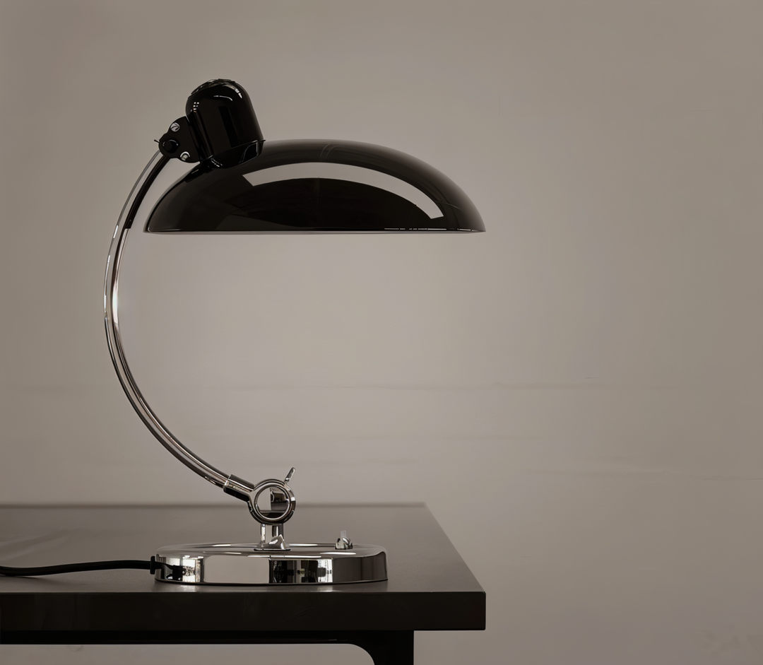 Justerbar bordlampe i jern med retrodesign og industriel stil, giver varmt lys til skrivebord eller læsehjørne.