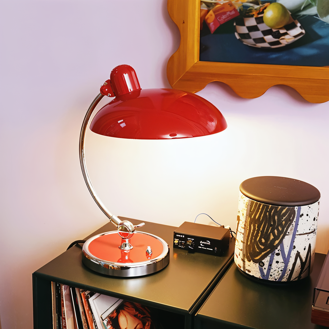 Justerbar bordlampe i jern med retrodesign og industriel stil, giver varmt lys til skrivebord eller læsehjørne.