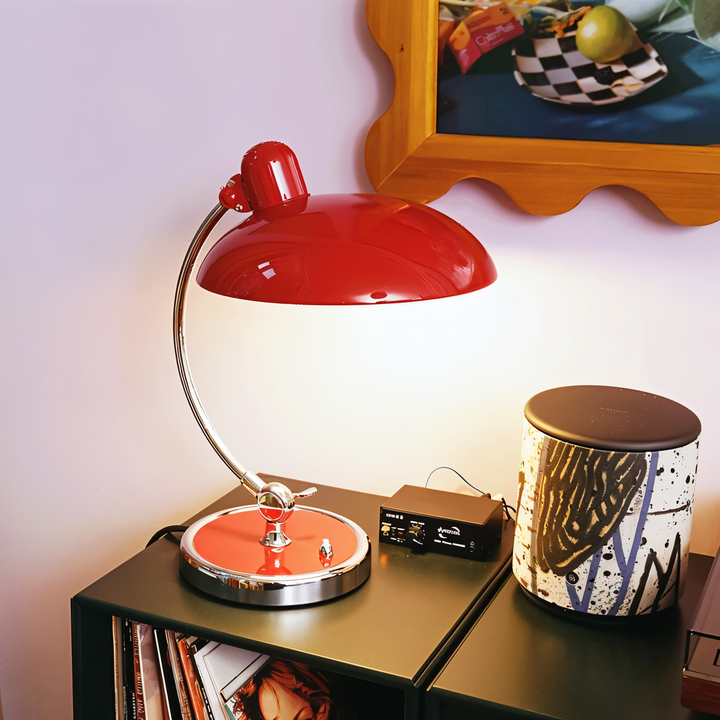 Justerbar bordlampe i jern med retrodesign og industriel stil, giver varmt lys til skrivebord eller læsehjørne.