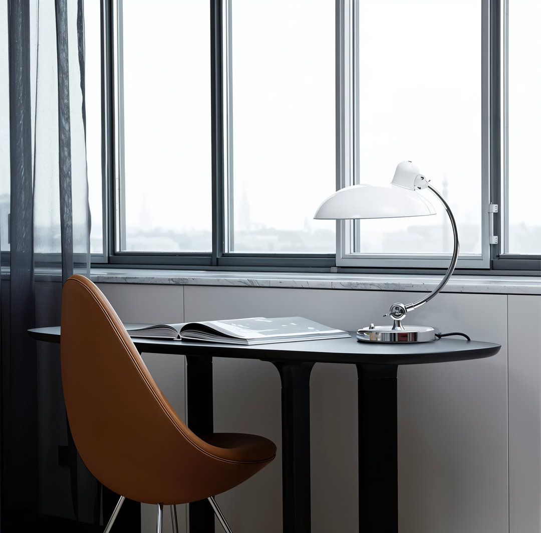 Justerbar bordlampe i jern med retrodesign og industriel stil, giver varmt lys til skrivebord eller læsehjørne.