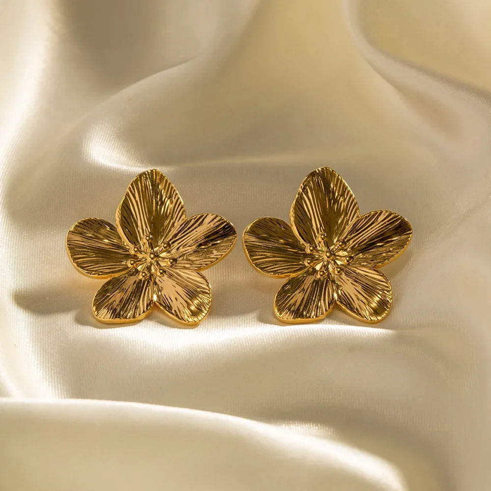 Nærbillede af dame vintage guldøreringe med detaljeret blomsterdesign. Festklare smykker.