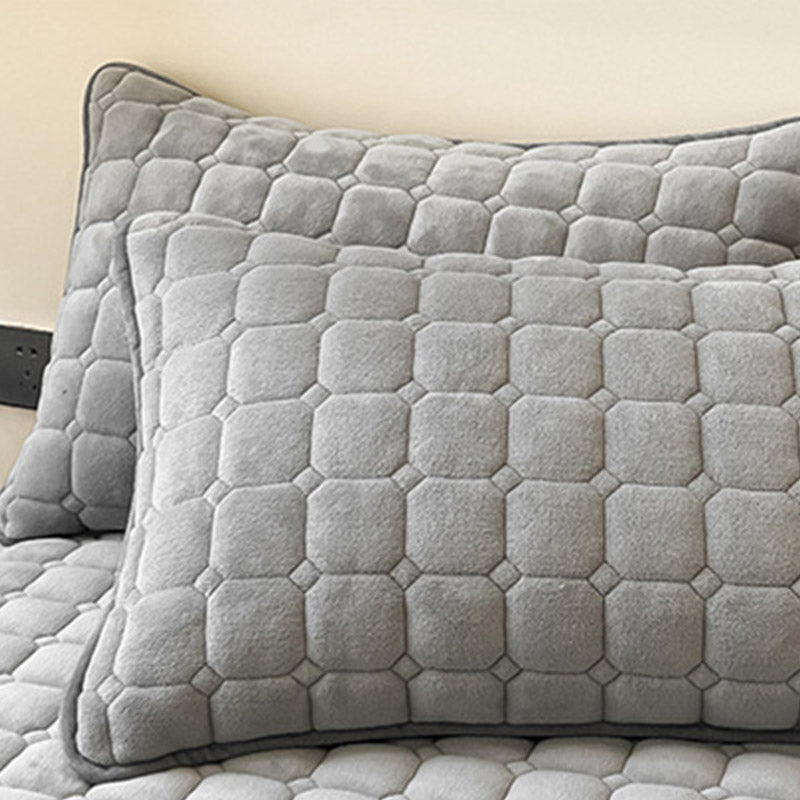 Blødt dagsengetæppe med kvadratisk tekstur, fluffy og moderne, draperet på sofaen for stilfuld hygge.
