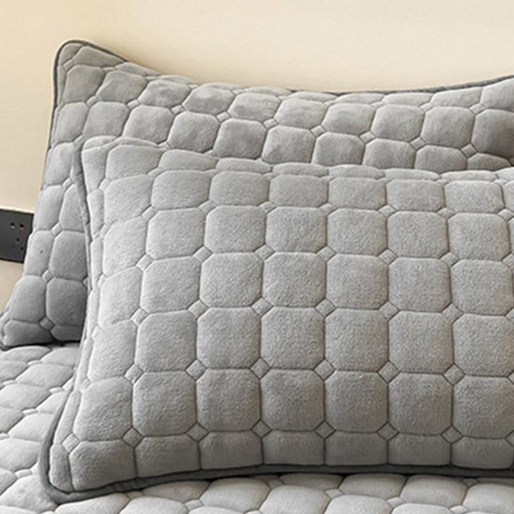 Blødt dagsengetæppe med kvadratisk tekstur, fluffy og moderne, draperet på sofaen for stilfuld hygge.