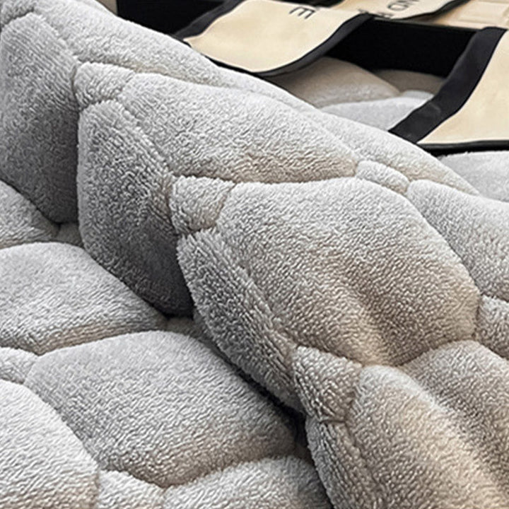 Blødt dagsengetæppe med kvadratisk tekstur, fluffy og moderne, draperet på sofaen for stilfuld hygge.