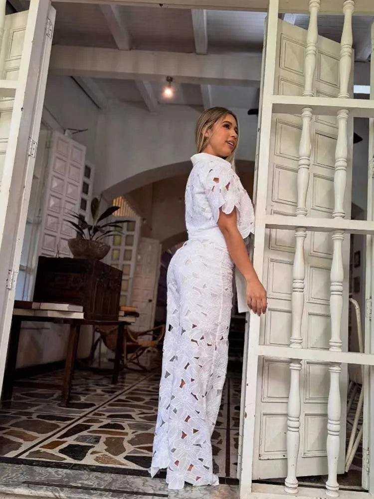 Let og luftigt todelt damesæt med blomstret blonde crop top og brede bukser til varme sommerdage.